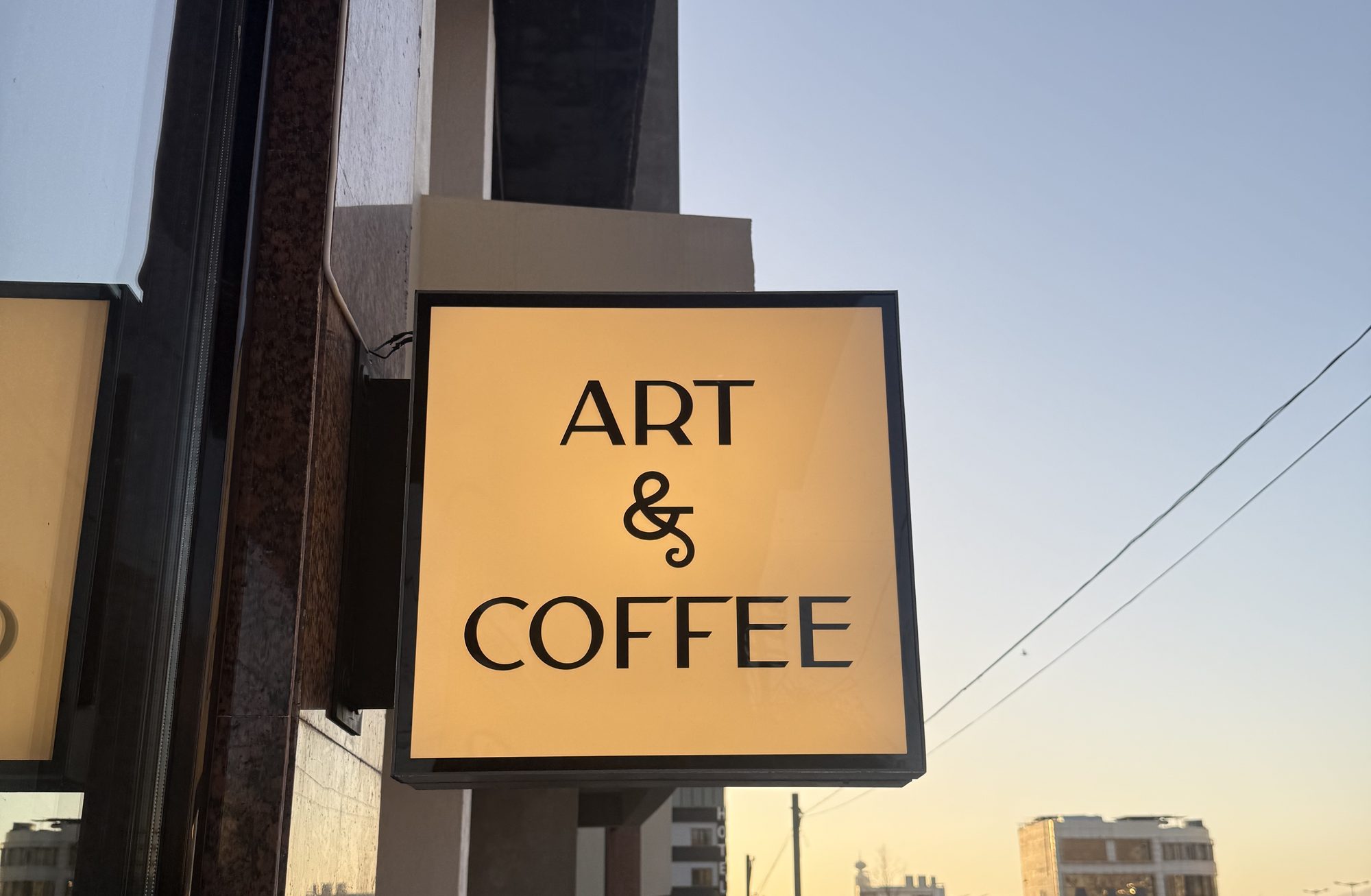 Art & Coffee's illuminated sign at sunset